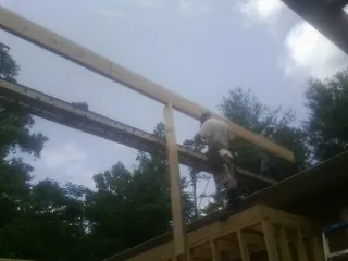 Carpenter setting a ridge beam over a new addition frame — Ice Dam Removal by Roofing Brothers in Trezevant