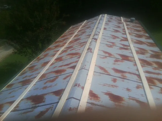 Rusted metal roof panels with new wood purlins before replacement — Storm Damage Roof Repair in Trezevant by Roofing Brothers