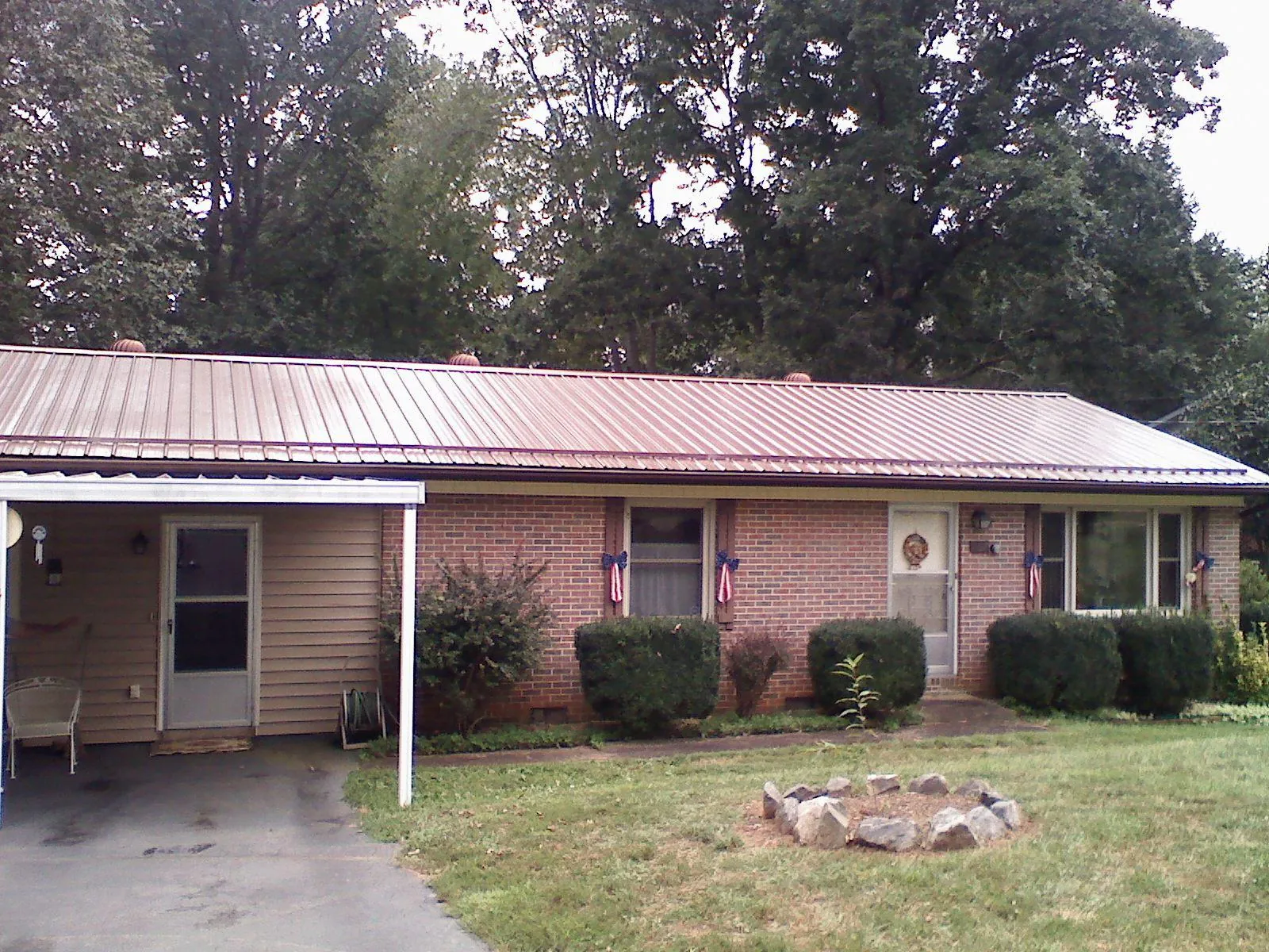 Bronze metal roof and carport on a brick ranch home — Roof Repair work by our crew in Trezevant